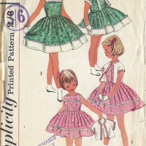 May include: A vintage sewing pattern for a girl's dress with a white collar and a matching jacket. The pattern is for size 6 and is from Simplicity.