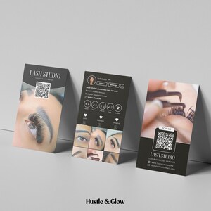 May include: Three black business cards for a lash studio. The cards feature close-up images of eyelashes, a QR code, and the studio's name. The cards are angled against a white wall.