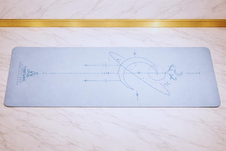 Pu&ograve; includere: Un tappetino da yoga azzurro con un design celeste. Il tappetino presenta una luna crescente, stelle e linee in blu pi&ugrave; scuro. Le parole "Yoga Spirit" sono stampate sul lato sinistro. Il tappetino &egrave; rettangolare.