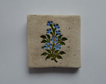 Handmade clay wall picture with forget-me-not imprint