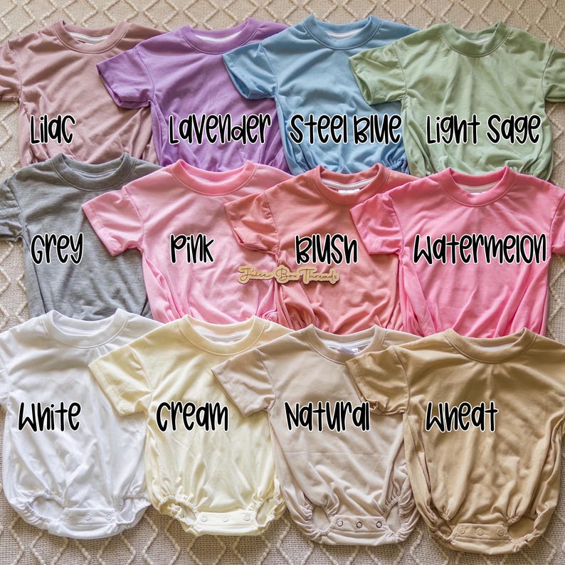 A collection of colorful baby onesies or rompers, each with a different color and pattern, laid out on a patterned surface.