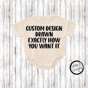 May include: Cream-colored baby bodysuit with short sleeves. The front of the bodysuit features the text "CUSTOM DESIGN DRAWN EXACTLY HOW YOU WANT IT" in bold black letters. A circular logo with the text "Double J Creations Kids" is in the lower right corner.
