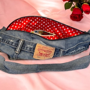May include: A blue denim crossbody bag with a red and white polka dot lining. The bag has a Levi's 511 label on the front.