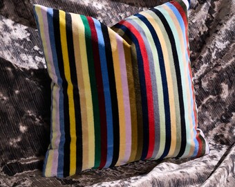 Disponible: Cojín de terciopelo a rayas arcoíris de 38x38 cm con cremallera roja o verde.