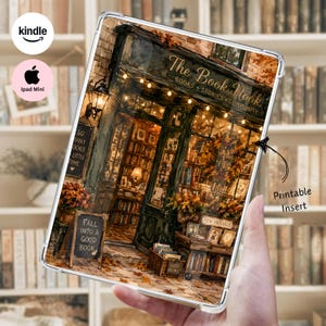 Op de afbeelding: Een doorzichtige tablethoes met een bedrukte inleg die de gevel van een gezellige boekwinkel toont. Het ontwerp bevat de tekst The Book Nook, Books, Stories, Community, Fall into a good book en New Arrivals, met warme lichtsnoeren en herfstbladeren.