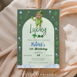 以下が含まれることがあります： 「Lucky One」と「Patrick's 1st Birthday」のテキストが入った、聖パトリックの日のテーマの招待状。招待状には、クローバーを持った緑の妖精の衣装を着た漫画の赤ちゃんが描かれています。日付は3月14日です。