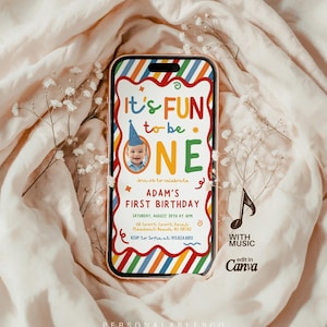 May include: A smartphone displaying a digital first birthday invitation with colorful diagonal stripes, a photo of a baby in a blue party hat, and the text It's FUN to be ONE, Adam's First Birthday, Saturday, August 30th at 4pm, and RSVP details.