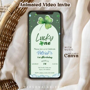 May include: A smartphone displaying an animated video invitation for a first birthday party. The screen features a green background with a watercolor shamrock, the text Lucky one, Patrick's 1st Birthday, March 14, 5:00 PM, and address details.