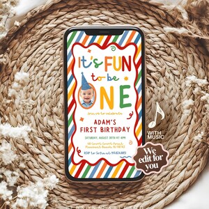 May include: A smartphone displaying a digital birthday invitation with a rainbow diagonal striped border. The text reads It's FUN to be ONE, Adam's First Birthday, Saturday, August 30th at 4PM, 68 Court Court Point, Pleasant Beach, NJ 08742.