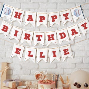 Könnte beinhalten: Ein Geburtstagswimpel im Baseball-Design mit weißen Wimpeln, roten Nadelstreifen und großen roten Buchstaben, die HAPPY BIRTHDAY ELLIE bilden. Die Girlande enthält zwei Wimpel mit Baseball-Motiven an den Enden und ist an einer Schnur befestigt.