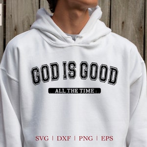 K&ouml;nnte beinhalten: Wei&szlig;er Hoodie mit schwarzem Text, der "God is Good All the Time" in einem Vintage-College-Schriftart-Stil lautet. Der Text ist abgenutzt und hat einen abgenutzten Look. Der Hoodie ist ein beliebtes Design f&uuml;r christliche Kleidung.