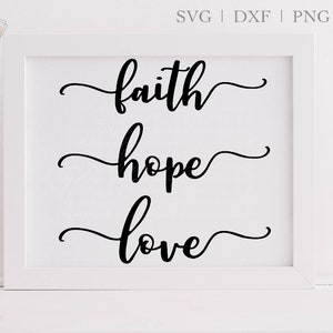 May include: White framed print with black calligraphy that reads "faith hope love" in a cursive font.