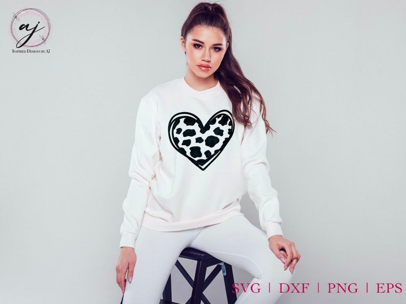 May include: A white sweatshirt with a black outline of a heart filled with a black and white leopard print pattern.