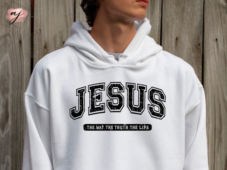 Op de afbeelding: Witte hoodie met het woord "JESUS" in een zwarte, versleten, collegiale lettertype. Daaronder staat de tekst "THE WAY THE TRUTH THE LIFE" in het zwart. De hoodie heeft een capuchon met trekkoord.
