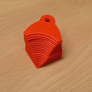 May include: A stack of bright orange plastic keychains shaped like a rounded triangle with a hole at the top.