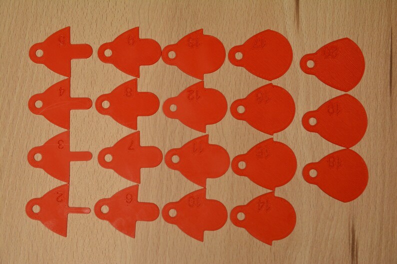 May include: Twenty red plastic tags with numbers 1 through 20 printed on them. The tags are shaped like teardrops with a small hole at the top.