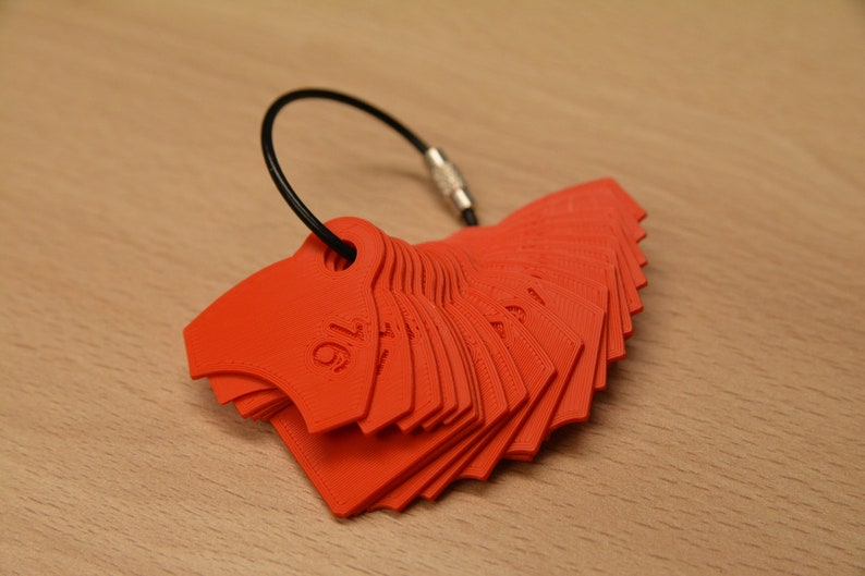 May include: A set of red plastic measuring tools, shaped like a fan, with a black cord attached. The tools are labeled with fractions, starting with 1/16.