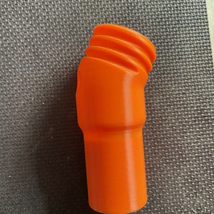 Puede incluir: Conector de plástico naranja impreso en 3D con un extremo roscado.