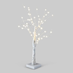Könnte beinhalten: Ein dekorativer Birkenbaum mit warmweißen LED-Lichtern. Der Baum hat einen weißen Rindenstamm und Äste und ist auf einem quadratischen weißen Sockel montiert. Die Lichter sind gleichmäßig über die Äste verteilt.