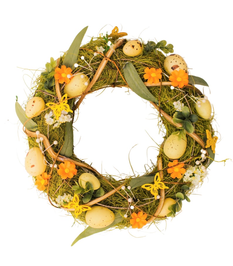K&ouml;nnte beinhalten: Ein gr&uuml;ner und brauner Osterkranz, der mit gelben und orangefarbenen Blumen, gelben Schmetterlingen und gelben, gefleckten Eiern verziert ist.