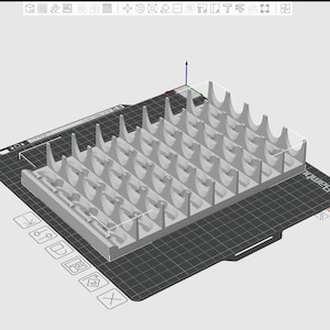May include: A light gray 3D-printed organizer with multiple curved slots and vertical supports. The organizer sits on a black surface with a grid pattern and the word "Bambu" printed on the side. The design includes various icons.