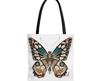 Könnte beinhalten: Eine weiße Einkaufstasche mit einem bunten Schmetterlingsdesign. Der Schmetterling hat braune, weiße, blaue und orange Flügel.