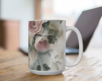 May include: White ceramic mug with a watercolor design of pink and green flowers. The mug has a large handle.