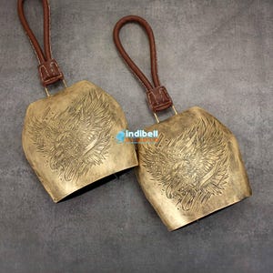 two pieces of gold bells shown on granite texture.