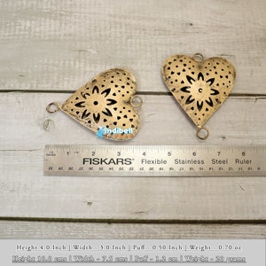 Two rustic heart-shaped metal cutouts with a ruler, showcasing size dimensions.