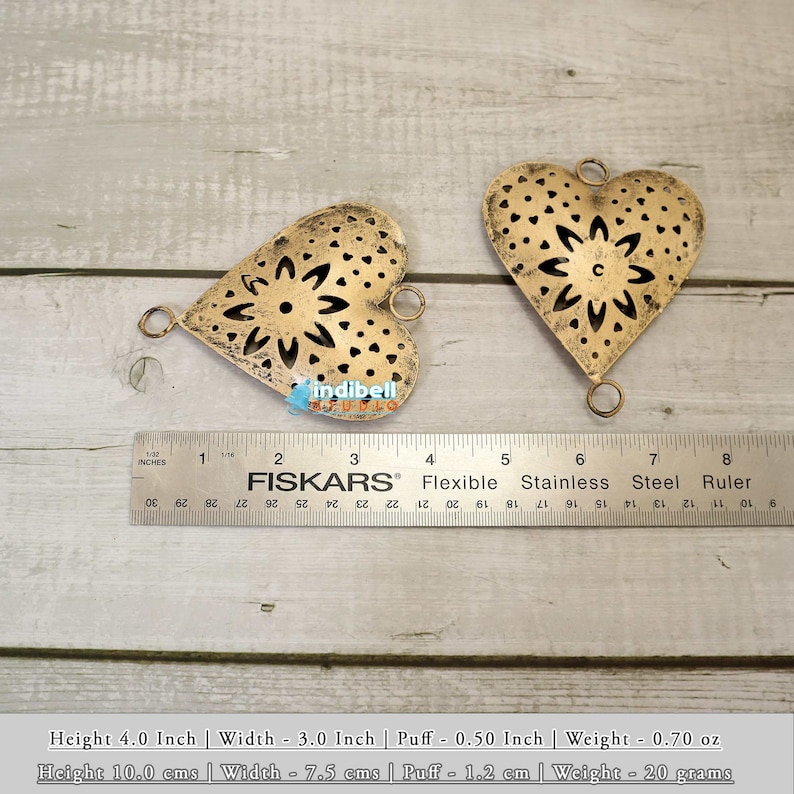 Two rustic heart-shaped metal cutouts with a ruler, showcasing size dimensions.