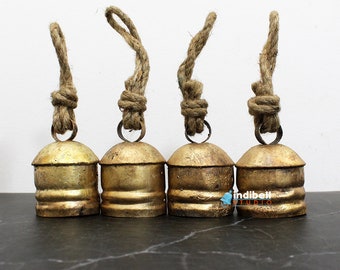 Puede incluir: Conjunto de cuatro campanas de metal de color dorado con asa de cuerda. Las campanas tienen un acabado desgastado y son perfectas para añadir un toque de encanto rústico a la decoración de tu hogar.