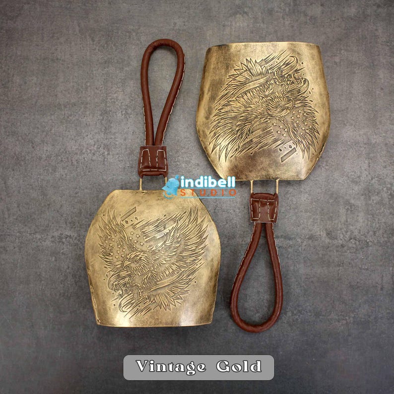 The gold color engraved bell is displayed here, The leather hanger is visible properly here.