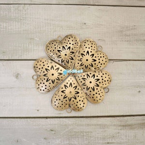 A circular arrangement of six rustic heart-shaped metal cutouts, creating a floral design.