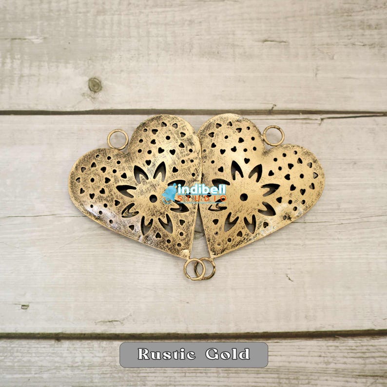 Two rustic heart-shaped metal cutouts placed side by side, forming a symmetrical pattern.