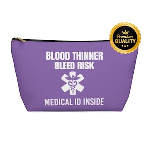 Puede incluir: Una bolsa morada con cremallera con el texto "BLOOD THINNER BLEED RISK" y "MEDICAL ID INSIDE" en blanco. Un símbolo médico blanco está centrado debajo del texto. Un sello dorado de "Premium Quality" está en la esquina superior derecha.