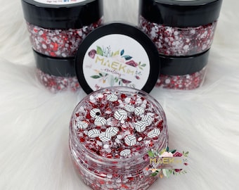 May include: Red glitter slime with white volleyball-themed charms in a clear jar with a black lid. The jar is labeled "Maekim Creations".