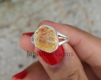 Può includere: Un anello d'argento con una pietra preziosa di citrino giallo grezzo. L'anello ha un design semplice e delicato ed è perfetto per l'uso quotidiano.