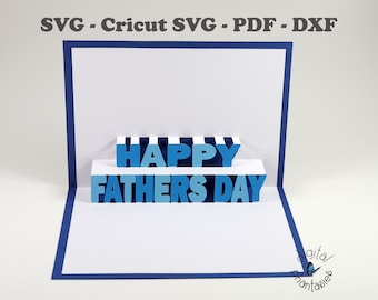 May include: A blue and white pop-up card with the words "Happy Father's Day" in blue letters. The card is folded and the letters are raised.