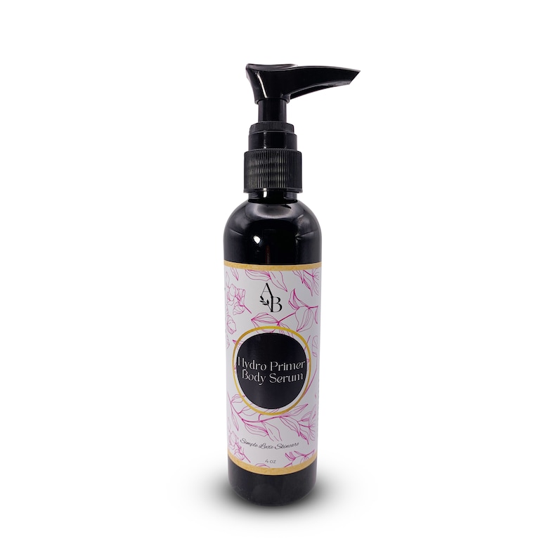 May include: A black bottle with a pump dispenser containing a body serum. The label is white with gold trim and pink floral designs. The text on the label reads "Hydro Primer Body Serum" and "Simple Luxe Skincare".
