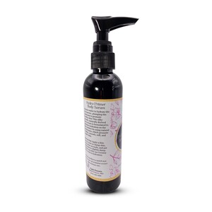 May include: A black bottle with a pump dispenser containing Hydro Primer Body Serum. The bottle has a gold label with pink floral accents and the text "Hydro Primer Body Serum".