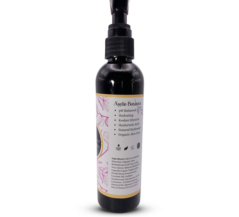 May include: A black bottle with a pump dispenser containing A'selle Botanics pH Balanced Hydrating Serum. The bottle label features a floral design and lists ingredients including organic aloe vera, kosher glycerin, and hyaluronic acid.