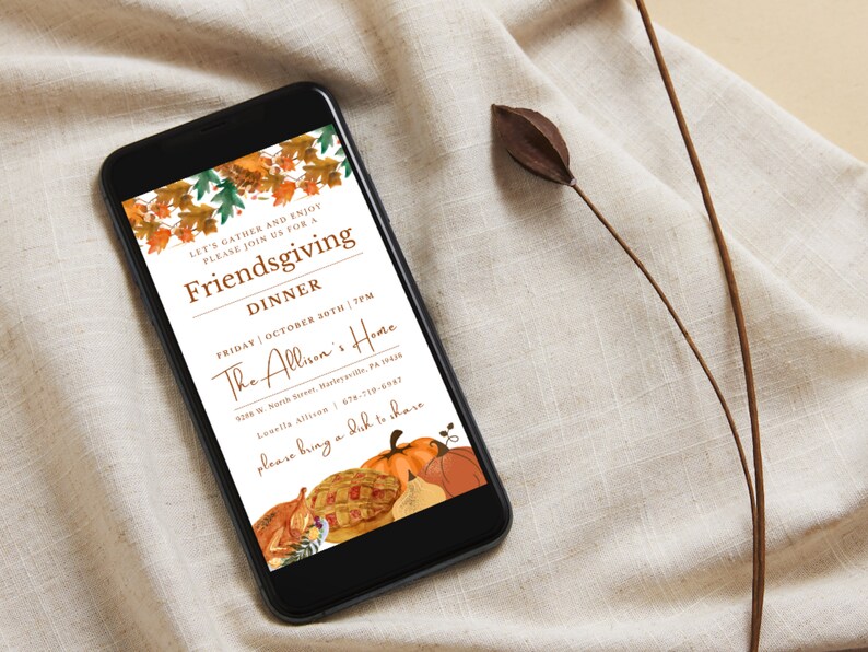 May include: A digital invitation on a smartphone screen for a Friendsgiving dinner. The invitation features a fall theme with autumn leaves, pumpkins, and a pie. The text reads "Let's gather and enjoy, please join us for a Friendsgiving Dinner, Friday October 30th | 7PM, The Allison's Home, 9286 W. North Street, Meyersville, PA 15845, Lonelle Allison 978-719-6987, please bring a dish to share."