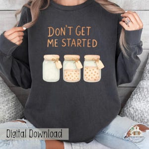 May include: Dark gray sweatshirt with the text "DON'T GET ME STARTED" above three mason jars. The jars have beige lids, tags, and varying contents, including one with polka dots. The words "Digital Download" are at the bottom.