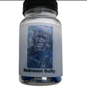 May include: A transparent glass bottle with a black lid, filled with blue capsules. The label features a blue and white image of a person and the text "Bedroom Bully".