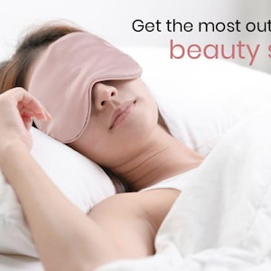 May include: A woman wearing a pink silk sleep mask is lying in bed. The text "Get the most out of your beauty sleep" is visible in the image.
