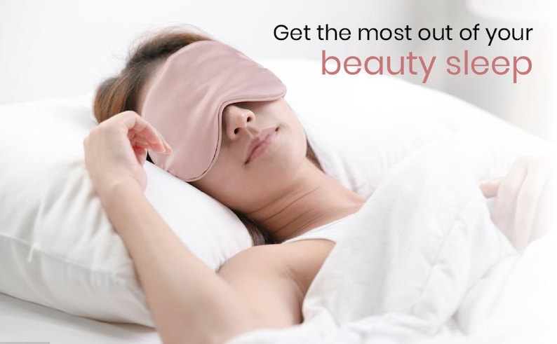 May include: A woman wearing a pink silk sleep mask is lying in bed. The text "Get the most out of your beauty sleep" is visible in the image.