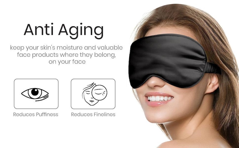 May include: A black silk sleep mask with an elastic strap. The text "Anti Aging" is above the mask. The text "Reduces Puffiness" and "Reduces Finelines" is below the mask.