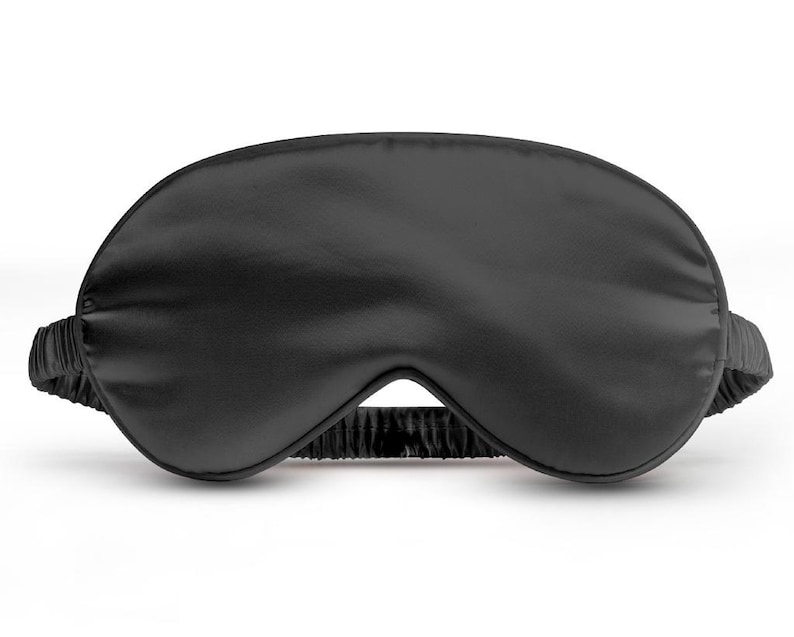May include: A black sleep mask made of soft, silky material. The mask is designed to block out light and help you sleep.
