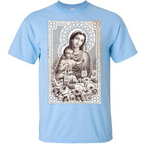Puede incluir: Una camiseta azul claro con una imagen vintage de la Virgen Mar&iacute;a y el ni&ntilde;o Jes&uacute;s. La imagen est&aacute; rodeada por un borde de encaje y dise&ntilde;os florales.
