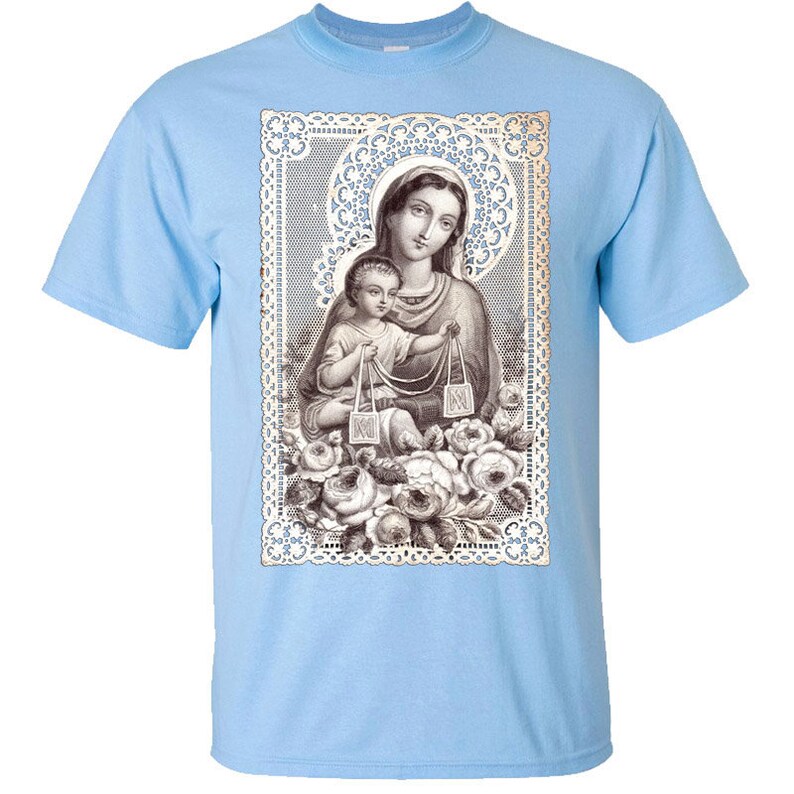 Puede incluir: Una camiseta azul claro con una imagen vintage de la Virgen Mar&iacute;a y el ni&ntilde;o Jes&uacute;s. La imagen est&aacute; rodeada por un borde de encaje y dise&ntilde;os florales.
